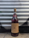 Rosé wine bottle with a minimalist kraft paper label set against a metallic shutter with graffiti accents in an urban Berlin setting.