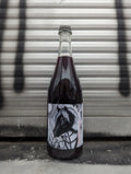 Sparkling red wine bottle with a bold, artistic label featuring a stylized horse illustration in black and white, accented with intricate patterns. Photographed against a metallic shutter backdrop, enhancing the urban aesthetic.