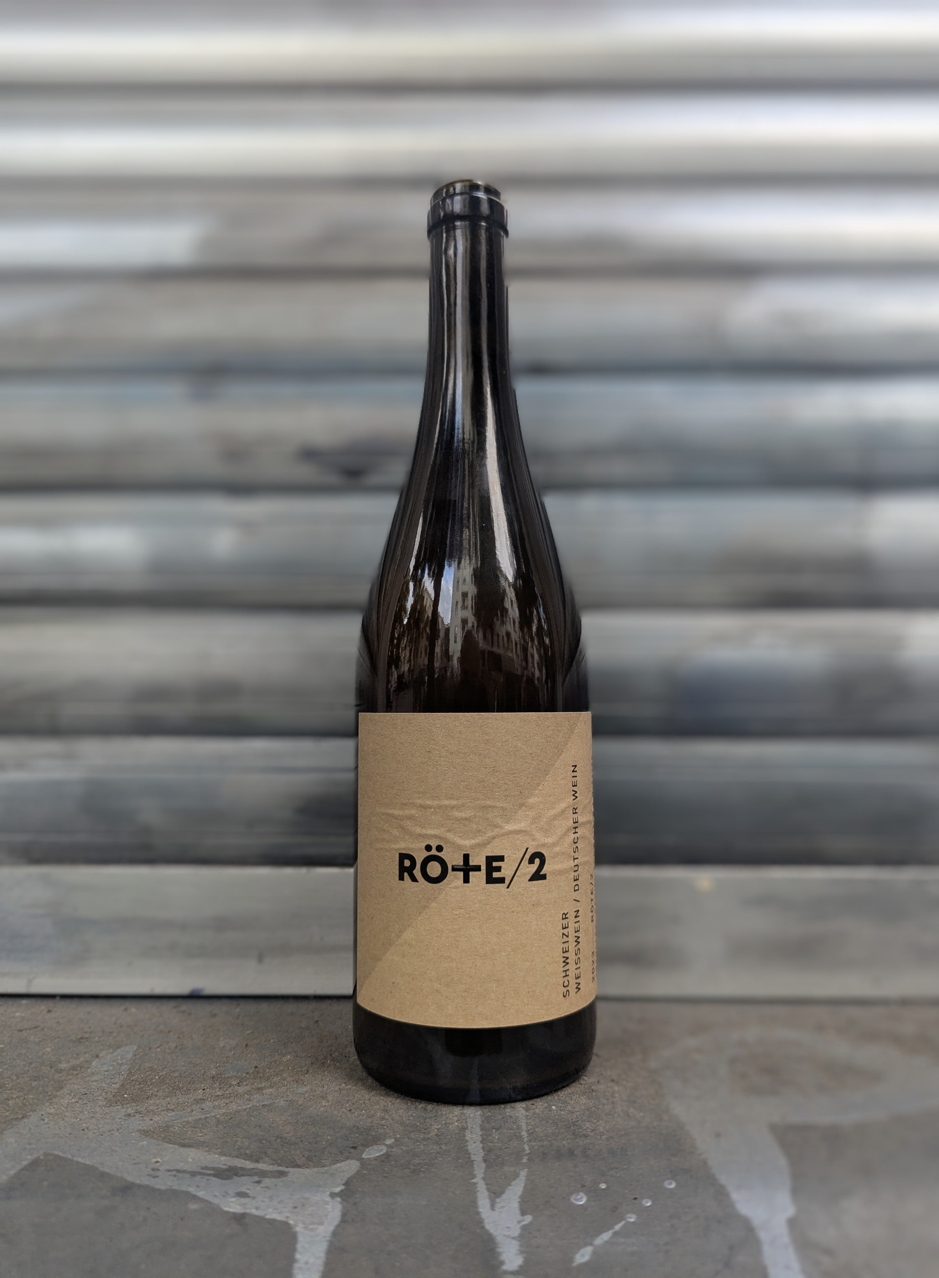 Dark glass bottle with a brown label on a gray surface and background