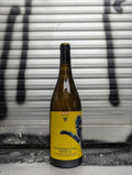 Bottle of Schlawiner Cuvée Natur 38 natural wine with a yellow artistic label, placed against a metallic background with black graffiti accents.